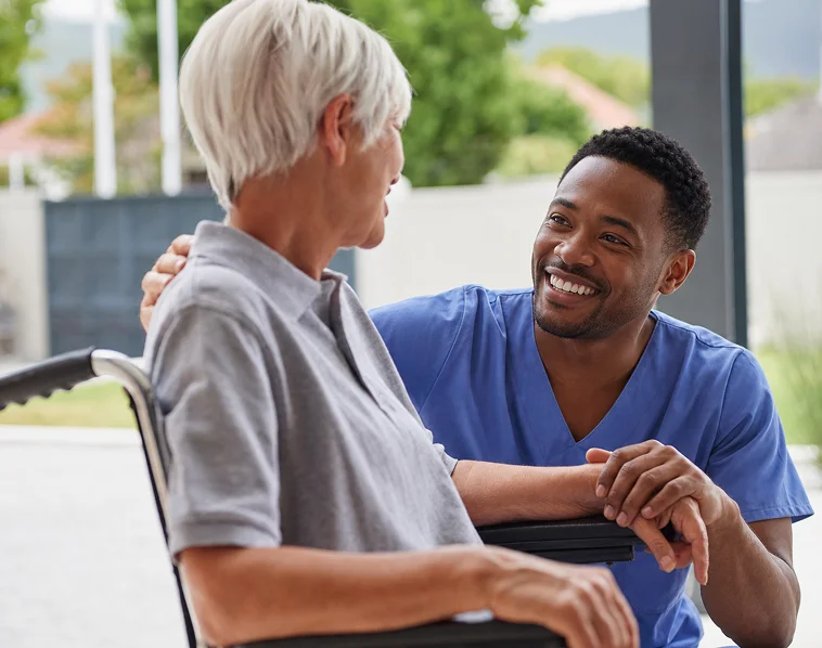 Caregiver talking with senior woman in wheelchair