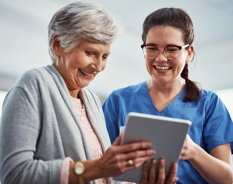 Caregiver using tablet with senior woman