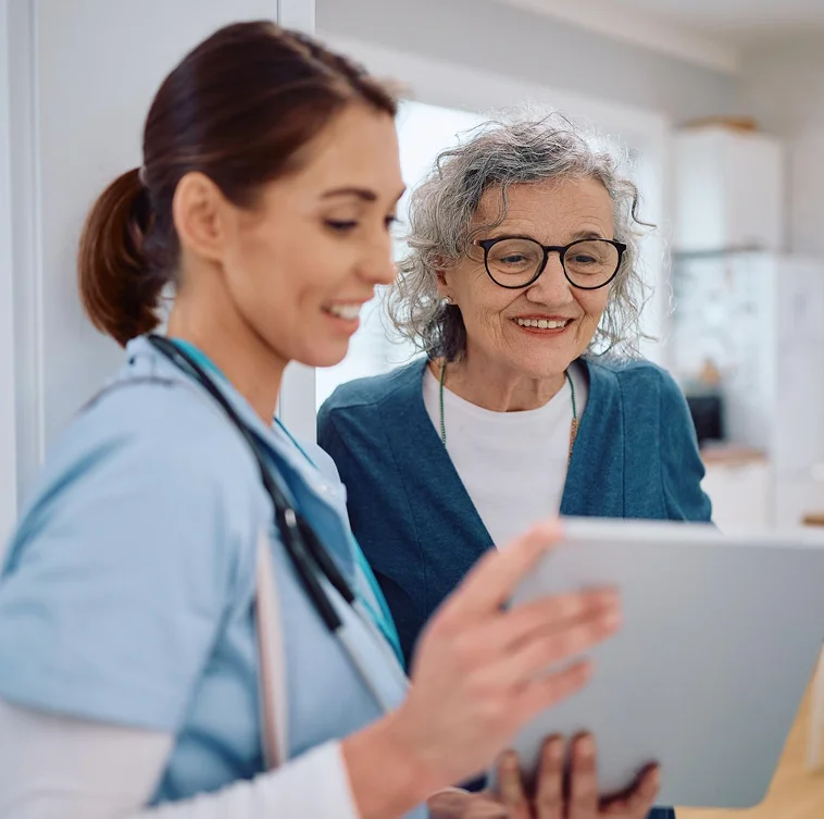 Caregiver showing tablet to senior woman